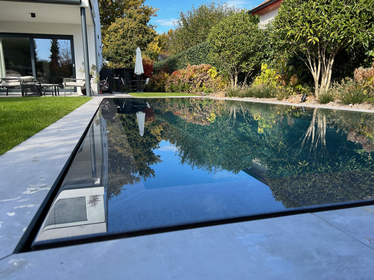 Création piscine miroir avec carrelage, volet solaire et nage à contre-courant à Genève