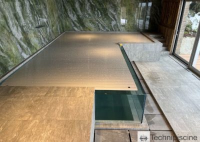 Piscine en verre avec débordement dans un chalet en Valais