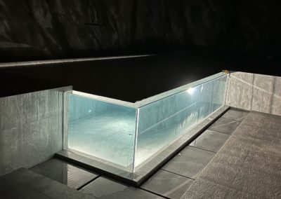 Piscine en verre avec débordement dans un chalet en Valais